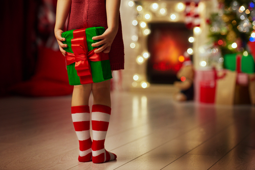 A girl holding a present for Christmas | The Joy of Giving
